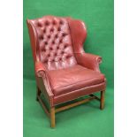 Red leather buttoned back wing armchair having removable seat cushion,