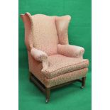 Georgian style upholstered wing back armchair standing on stretchered square tapering legs ending