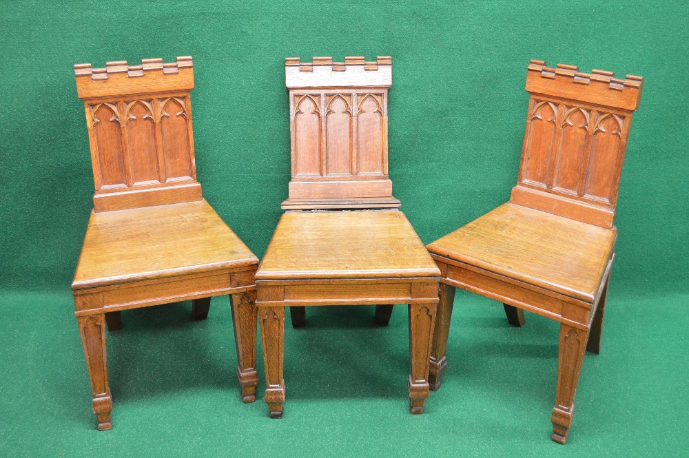 Set of three oak hall chairs having Gothic style panelled backs over solid seats,