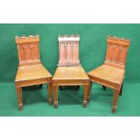 Set of three oak hall chairs having Gothic style panelled backs over solid seats,