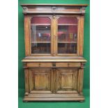 Continental walnut glazed bookcase having two glazed upper doors enclosing two adjustable shelves