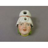 An early 20th century German flower holder in form of a ladies face