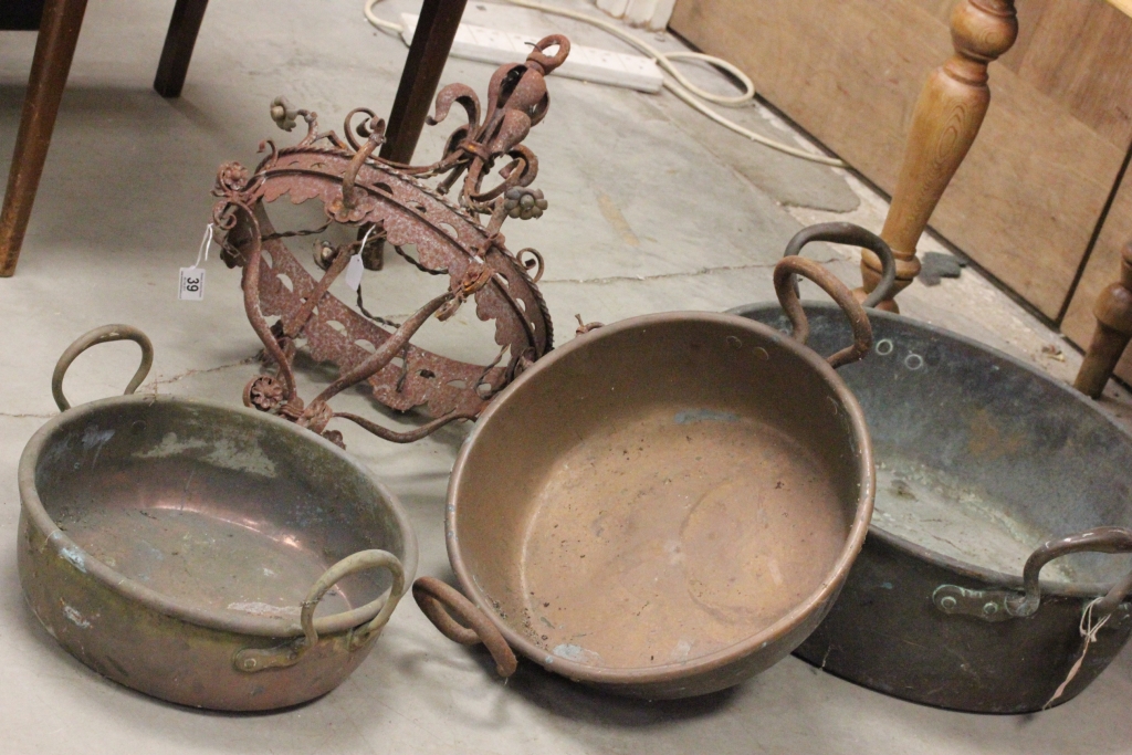 A large copper pan, along with two other pans and a hanging light