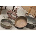 A large copper pan, along with two other pans and a hanging light