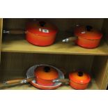 Five piece orange Le Creuset cooking set to include four saucepans and one frying pan