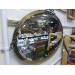 A large oval mirror in a brass surround