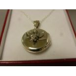 A silver locket with cherub to the case on silver chain cased