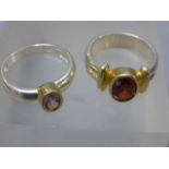 Two silver rings one set with a garnet and the other an amethyst