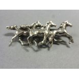 Silver brooch depicting three horses galloping