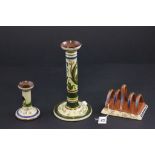 A Torquay ware candlestick, along with another candlestick and a toast rack