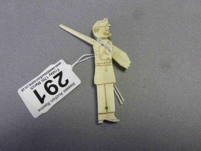 An early 20th century carved bone figure of a military gentlemen holding a rifle