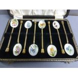 A cased set of early 20th century brass spoons, each enamel bowl painted flowers and plants, cased