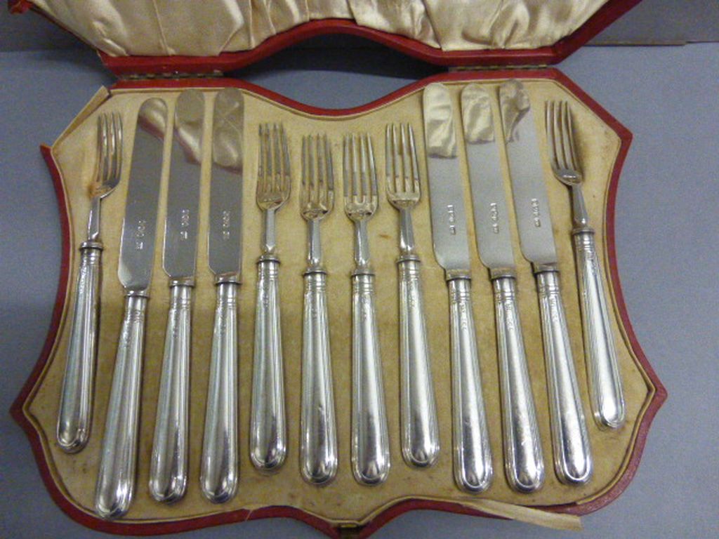 A cased set of of silver dessert 6 fork and 6 knives, in a red leather fitted case, Sheffield 1927