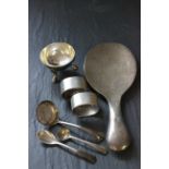 A small collection of silver items to include a pair of napkin rings, single salt cellar, silver