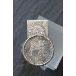 A silver money clip mounted with replica American silver dollar