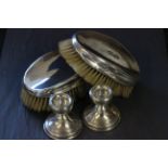 Pair of silver brushes plus a pair of silver candlesticks