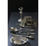 A collection of silver items including 7 napkin rings, single weighted candlestick, pierced dish and