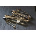A collection of 19th and 20th century silver sugar tongs, various dates and makers