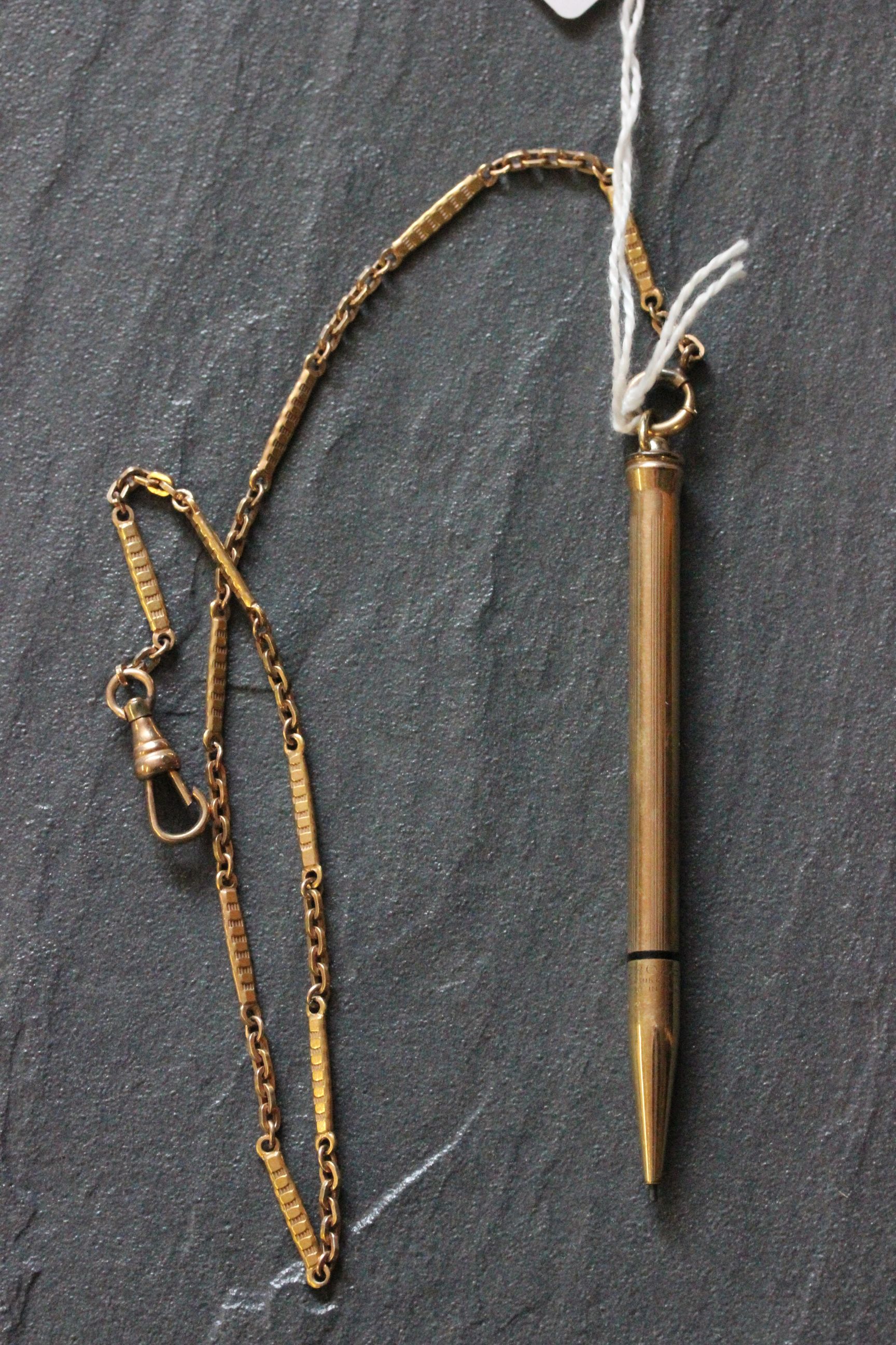 Yellow metal watch chain with cross pen