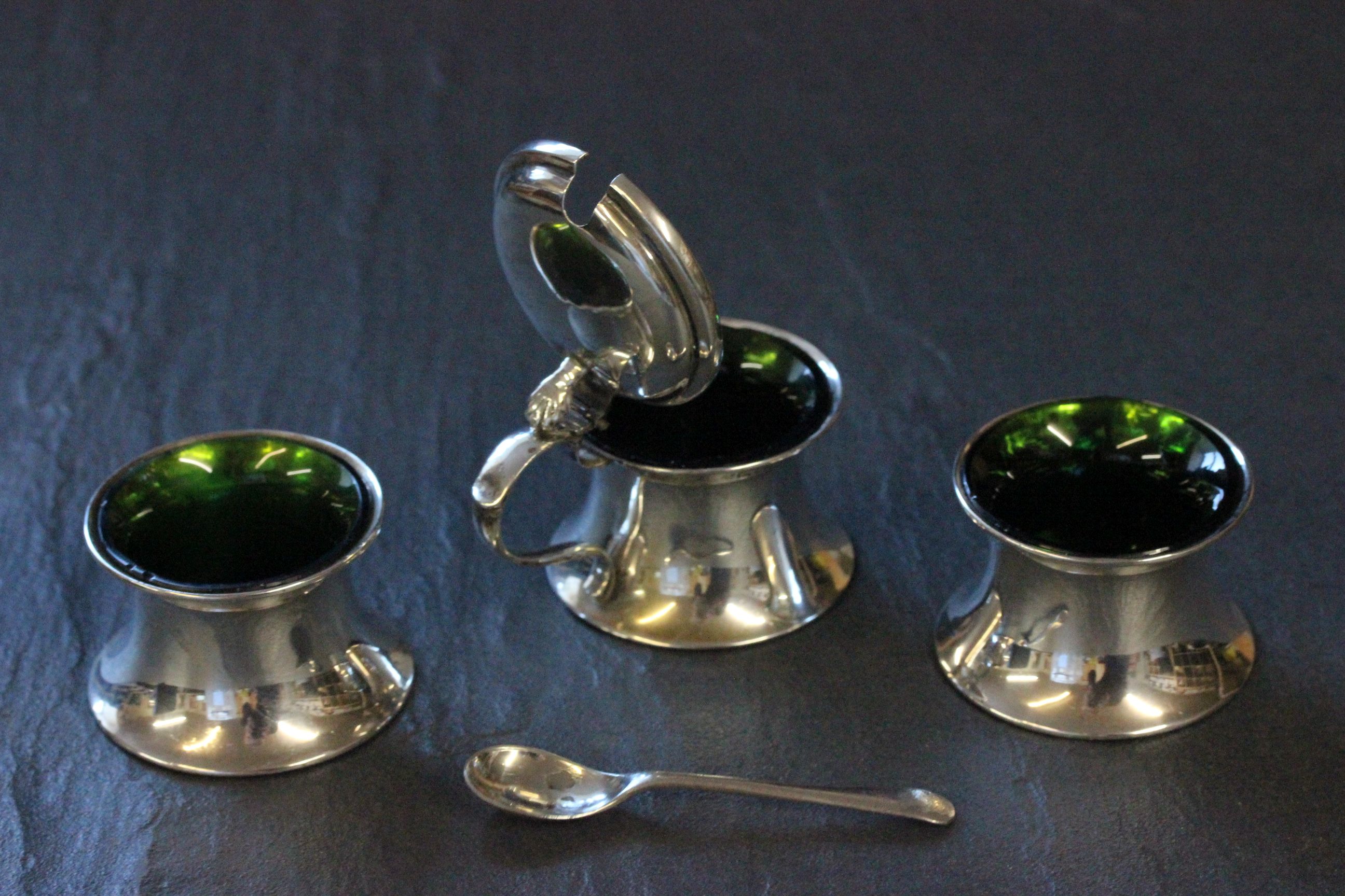 A three piece silver cruet set, with green glass liner and matching spoon, Birmingham 1910