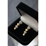 Pair of 14ct yellow gold graduating diamond set heart shaped earrings