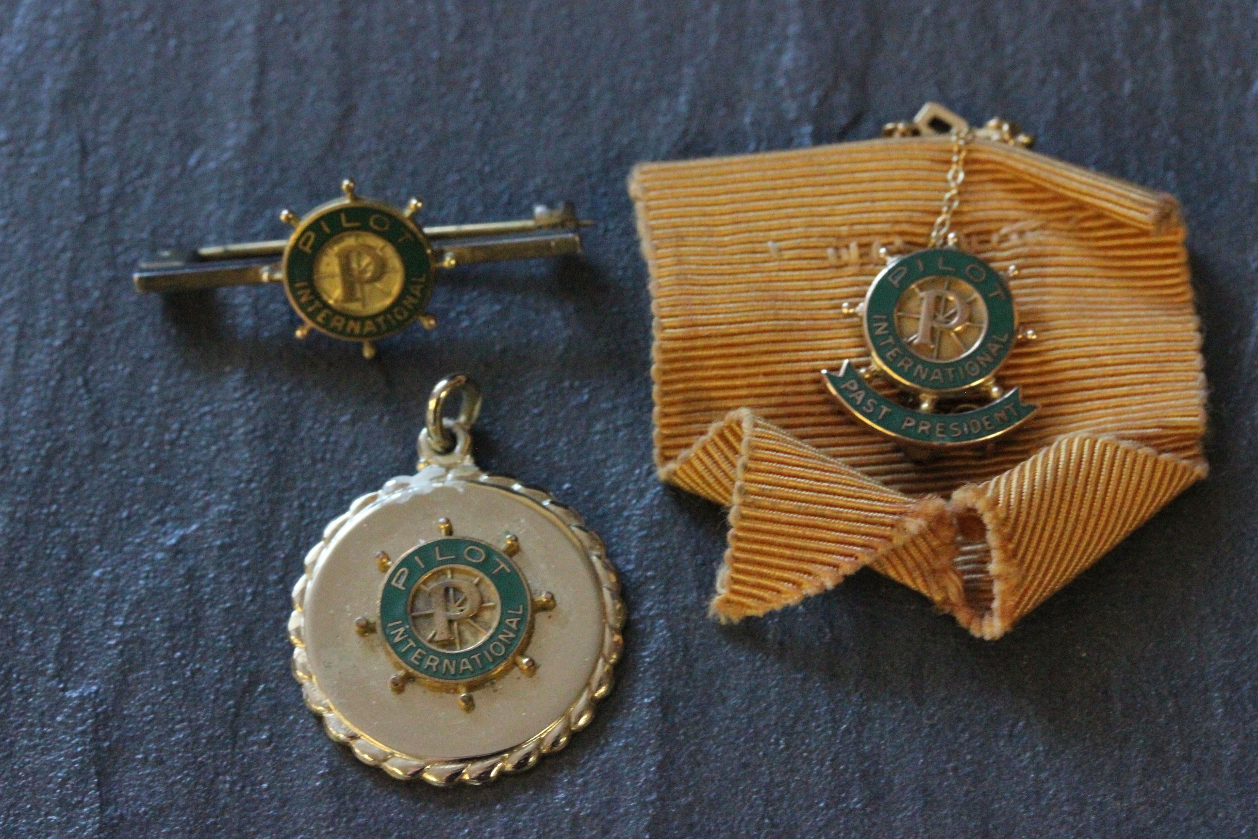 Three Pilot International badges including 10k gold & enamel