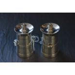 A pair of silver novelty pepperettes, each in the form of milk churns with carry fixed handles, each