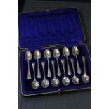 A cased set of silver teaspoons, each with an engraved stem, in leather fitted case, Sheffield 1906