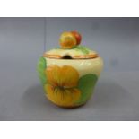 A Clarice Cliff Bizarre preserve jar and cover, decorated with nasturtium throughout, 8.5cm high,