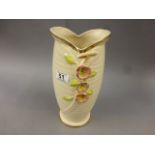 A pink ground vase by Arthur Wood, decorated with three central flowers, 29cm high