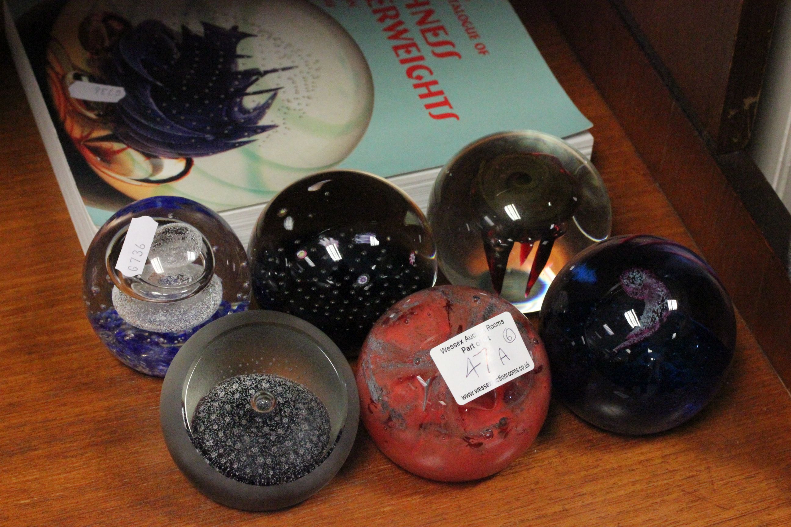 Six caithness glass paperweights plus a related book