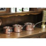 Three Graduating French Copper ' Mauviel ' Saucepans with lids and iron handles