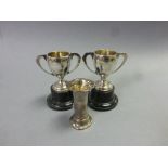 Two silver trophies on stands and a small silver vase