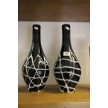 A large pair black art glass bottle vases