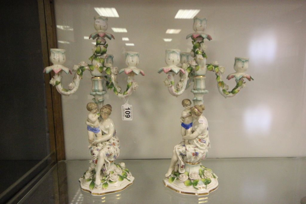 A pair continental ceramic two section candelabra with a seated lady holding a boy