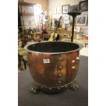 A large copper log bucket on lion paw feet