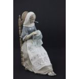 A Lladro figure of a seated lady knitting