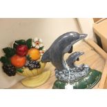 Two cast iron door stops in the form of a dolphin and fruit bowl