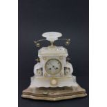 An alabaster mantel clock on a gilt wooden base