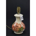 A Moorcroft lamp decorated on a cream ground with hibiscus flowers