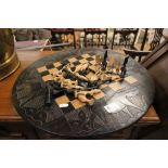 A wooden circular chess board together with hand carved African Chess Set in the form of Birds