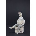 A Nao figure of a seated boy