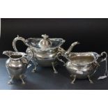 A silver three piece tea service comprising teapot, sugar bowl and milk, with rim of each piece