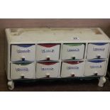 Unusual painted wooden spice cupboard with eight drawers, each having a ceramic plaque in German