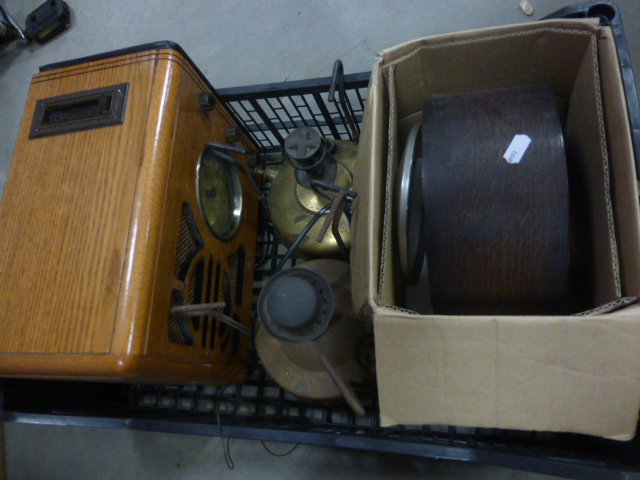 Two vintage brass paraffin lamps, a oak cased mantle clock and a wooden cased radio.