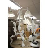 Cast metal lamp with glass shades, on tripod feet featuring a Cherub on swing plus three other