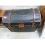 An antique leather domed topped trunk .
