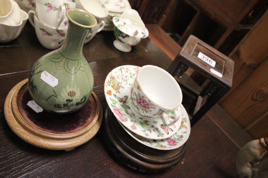 Four pieces of Oriental ceramics and three hardwood pot stands