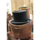 An antique silk top hat and leather case