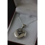 A silver locket with cherub on silver chain, cased